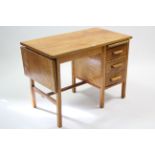 A pine & oak drop-end typist’s desk fitted three long drawers to the right-hand side, & on square