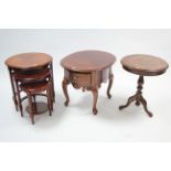A mahogany-finish nest of three circular occasional tables; together with a similar oval