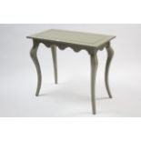 A continental-style pale green painted wooden rectangular centre table with shaped apron, & on