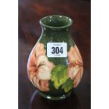 A Moorcroft pottery ovoid vase of green ground & with stylised floral design, 5¼” high.