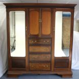 A late 19th/early 20th century mahogany combination wardrobe with blind fret-work cornice, with