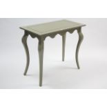 A continental-style pale green painted wooden rectangular centre table with shaped apron, & on