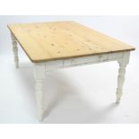 A pine farmhouse table with rounded corners to the rectangular top, the white painted underside