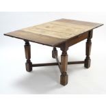 A mid-20th century oak draw-leaf dining table on turned & square tapered legs with diagonal