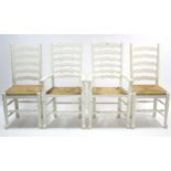 A set of four white painted oak ladder-back kitchen chairs (including a pair of carvers) with