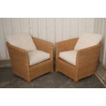 A pair of wicker swivel conservatory chairs, with buttoned loose cushions to the seats & backs.