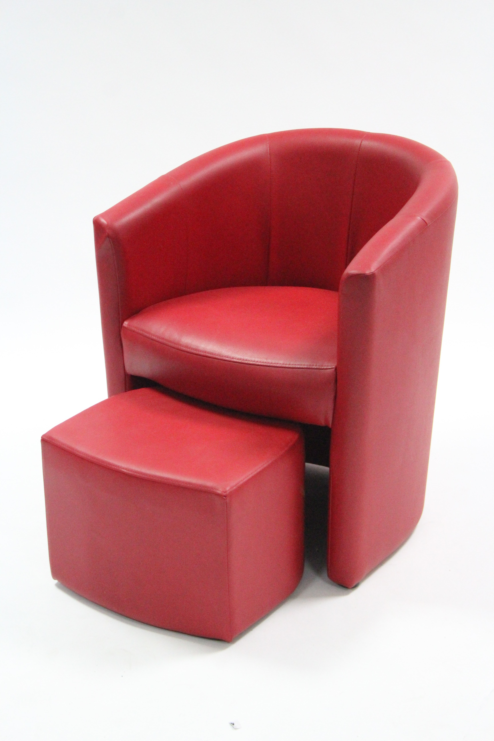 A crimson leatherette tub-shaped chair & foot rest.