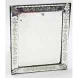 A Venetian-style rectangular wall mirror with foliate design to the bevelled border, 29” x 23½”.