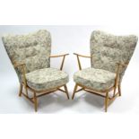 A pair of Ercol light elm frame buttoned-back armchairs, on round tapered legs with spindle