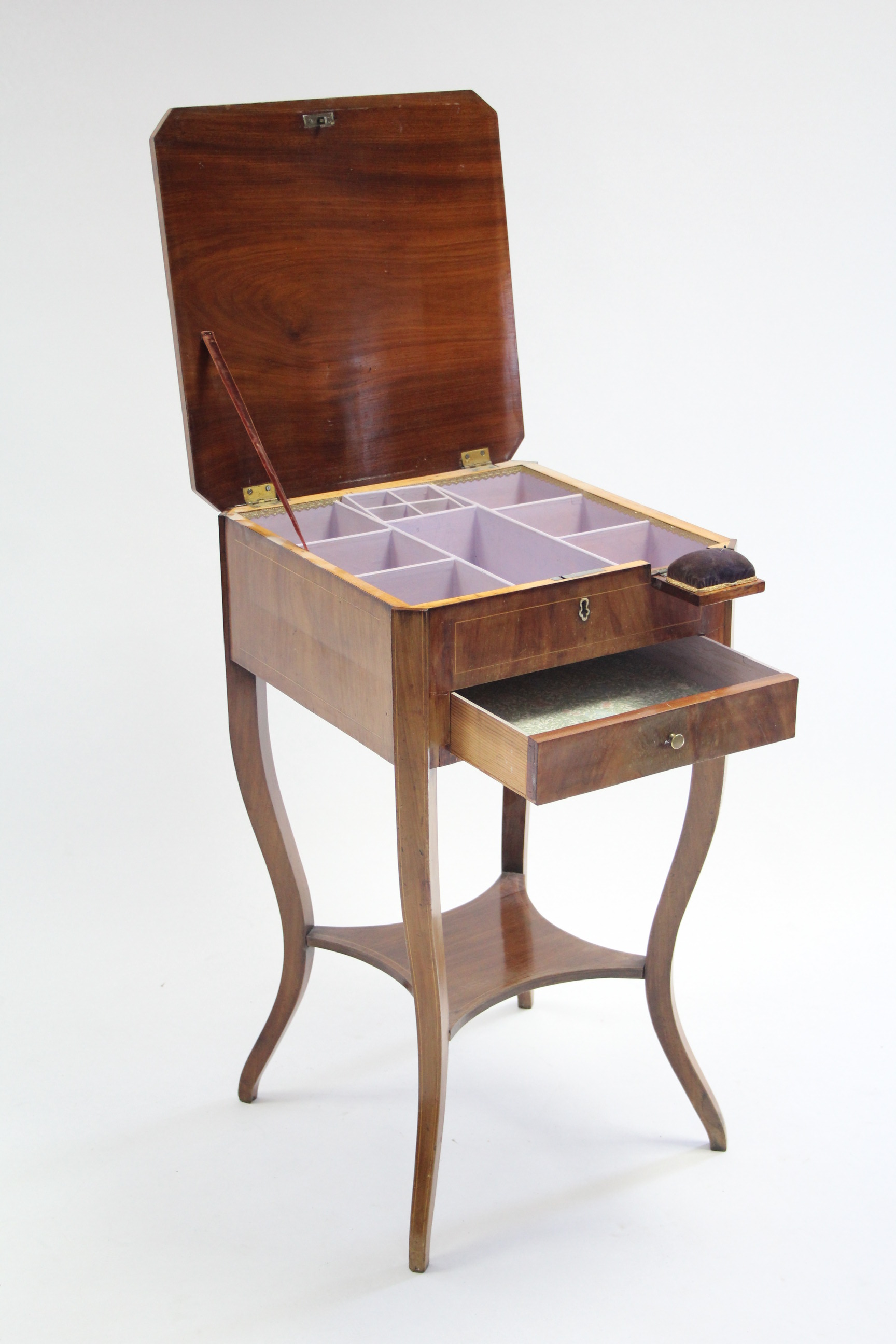 A 19th century continental inlaid mahogany work table with hinged top enclosing numerous interior