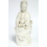 An 18th century Chinese blanc-de-chine figure of Guanyin, seated, with an infant on her lap; 10”