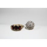 A 9ct. gold ring set three graduated oval garnets; & another set cluster of white stones.