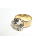 A WHITE TOPAZ RING, the large circular stone approx. 6 carats, set to a heavy yellow metal shank;