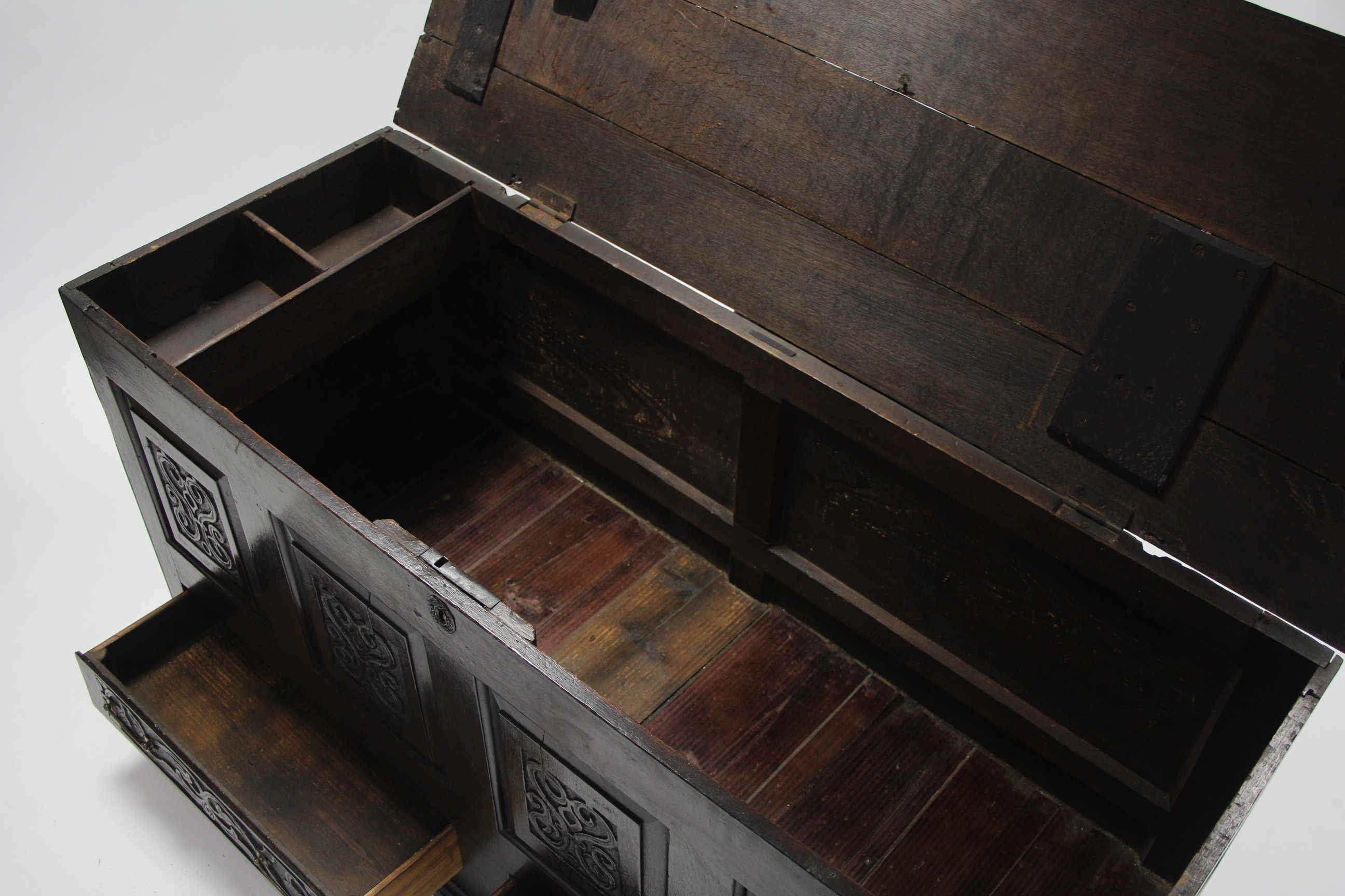 A late 17th century oak coffer with hinged lift-lid, having four carved panels to the front above - Image 3 of 4