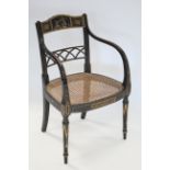 A regency ebonised beech elbow chair, the top rail painted en-grisaille with two putti tussling over