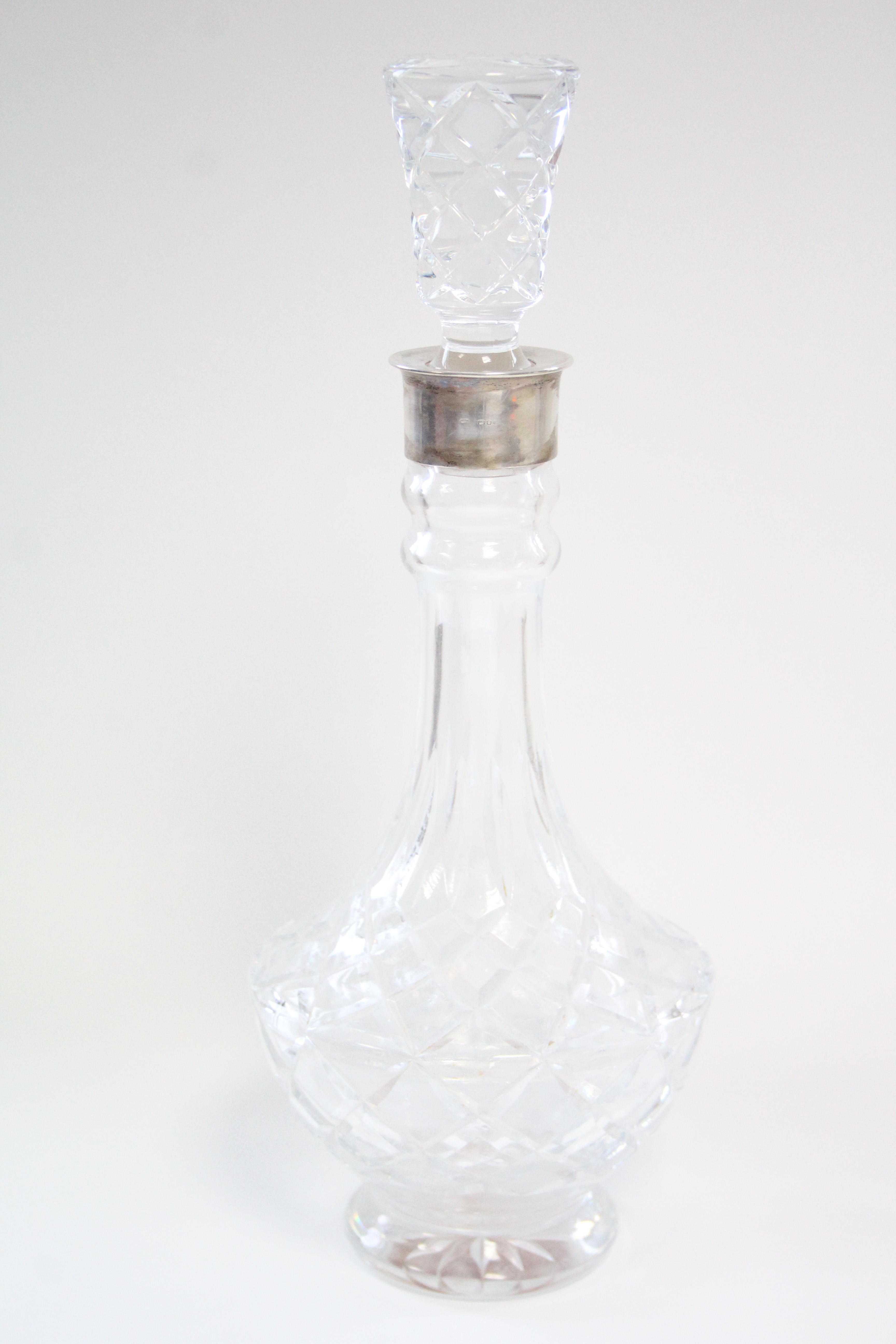 A good quality heavy cut glass baluster-shaped decanter with tall narrow neck & silver-mounted