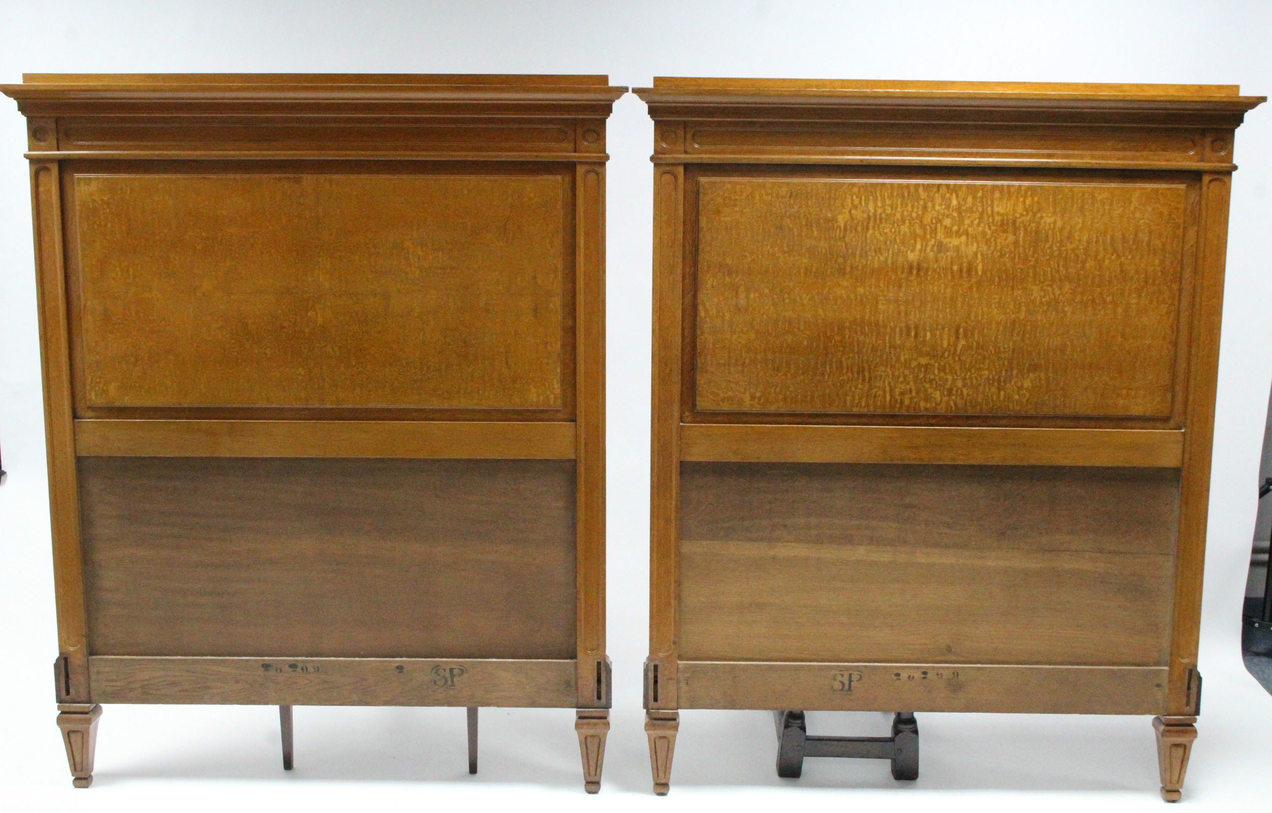 A pair of Edwardian oak & burr-elm single bedsteads with carved head & footboard, on square tapering