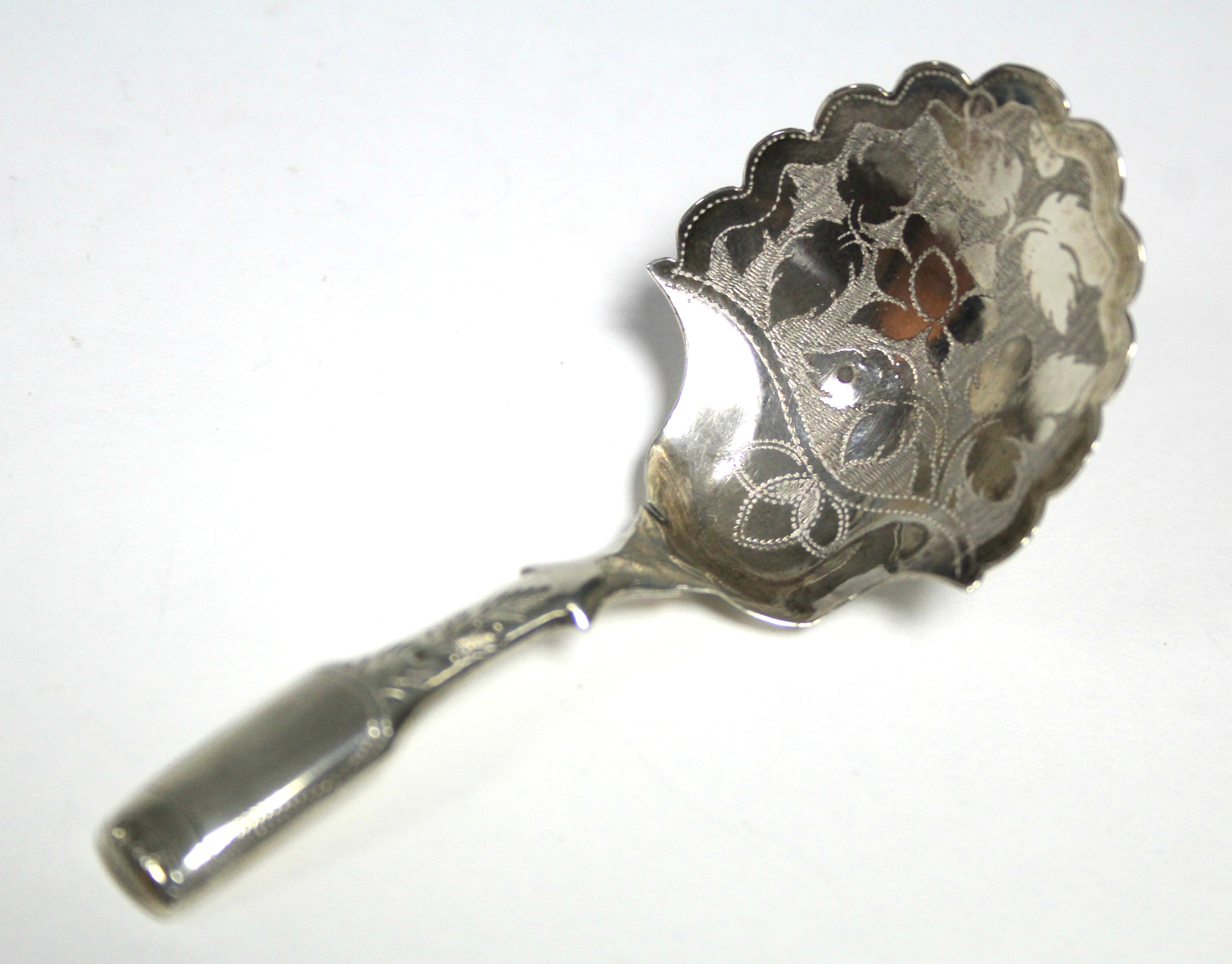 A George IV Fiddle pattern caddy spoon, the rounded shovel bowl with scalloped rim & engraved floral