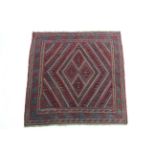A tribal Kazak rug of blue, crimson & ivory ground with central geometric design within multiple