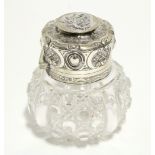 A late Victorian cut glass perfume bottle of squat round form, the embossed tall hinged cover with