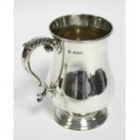 A Victorian baluster-shaped pint mug with foliate scroll handle, 5¼” high. London 1884, by Geo.