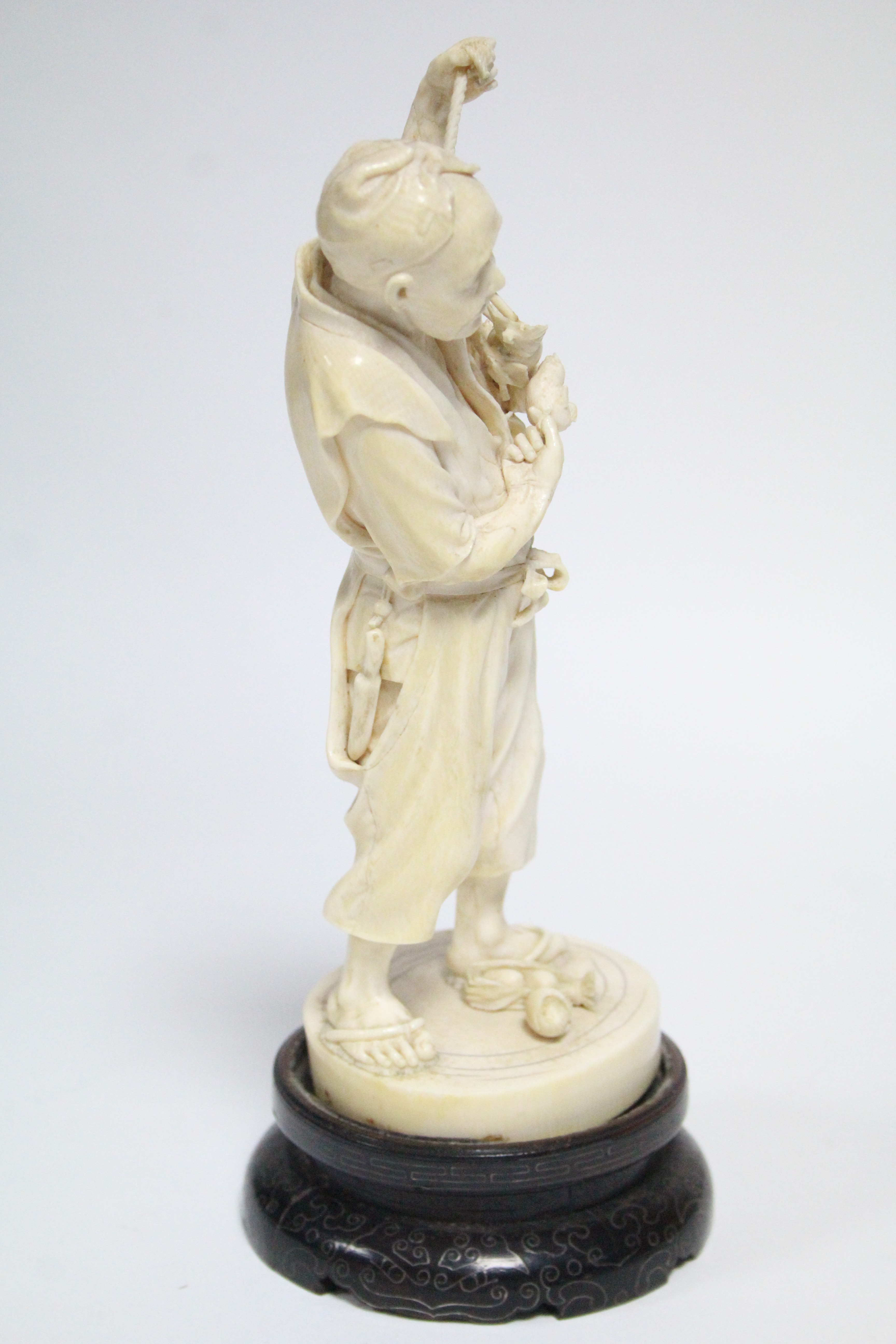 A LATE 19th century JAPANESE IVORY OKIMONO of a standing male farmer holding aloft a fruit-laden - Image 2 of 7