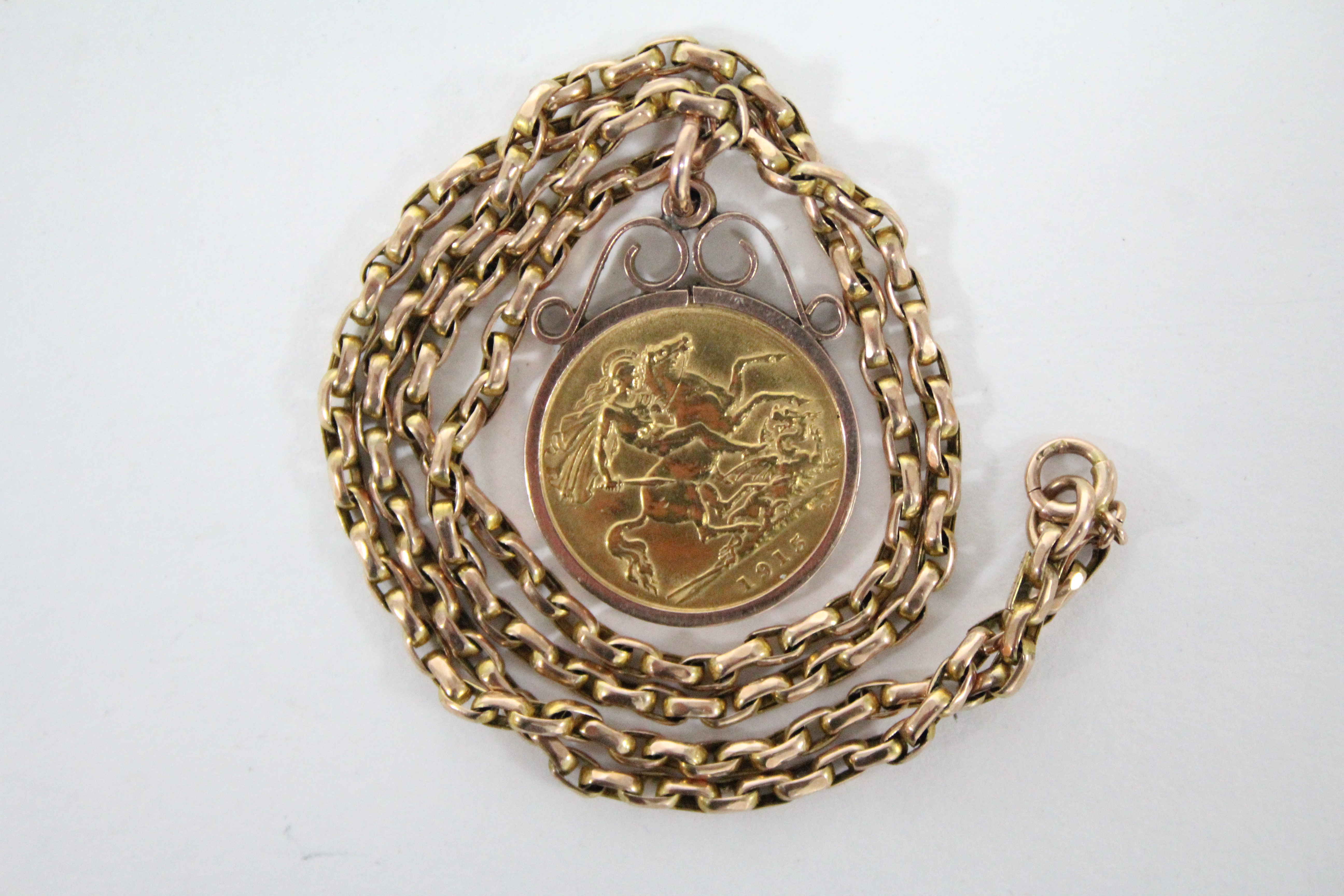 A George V half-sovereign, 1915, loose-mounted as a pendant, on 9ct. gold chain necklet.