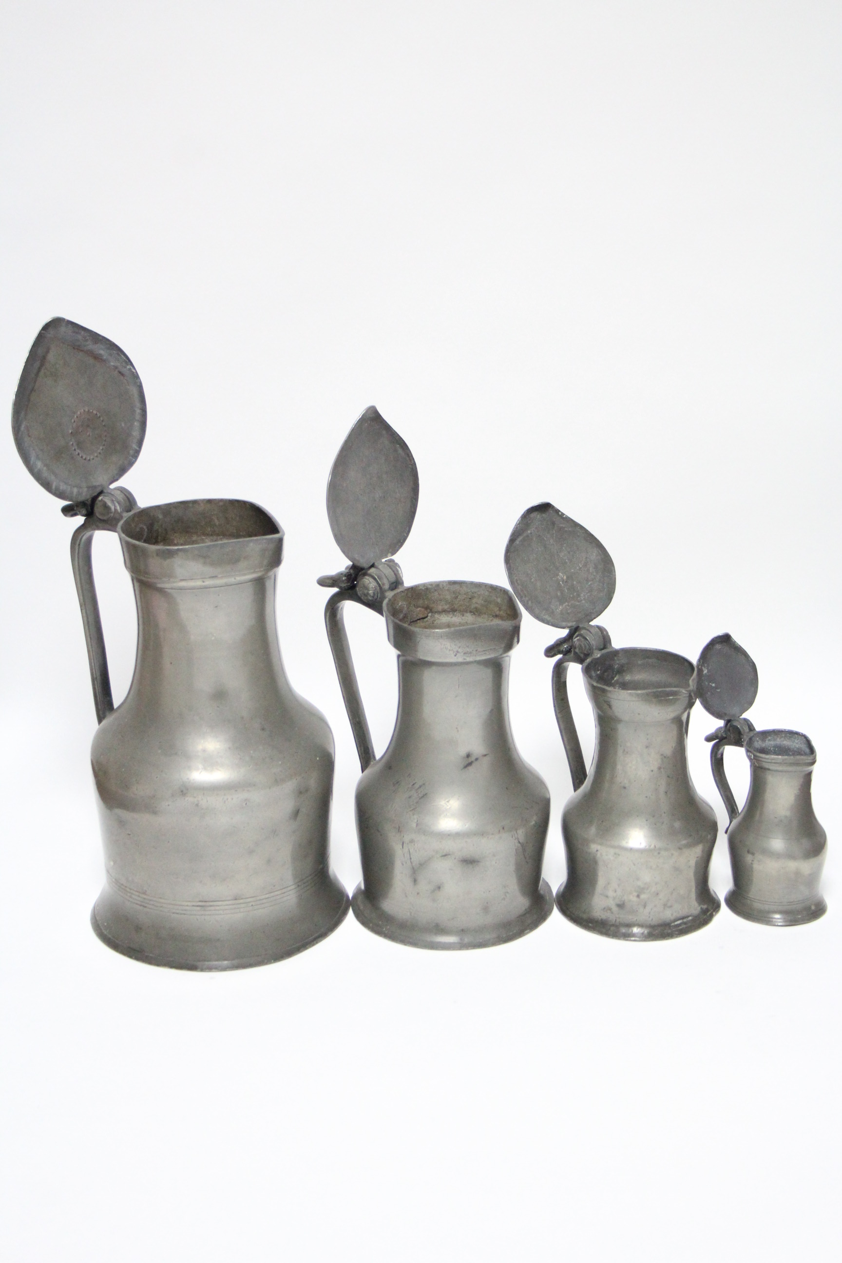 A matched set of four 19th century pewter graduated “Tappitt Hen” jugs, with double-acorn, thumb- - Image 2 of 2