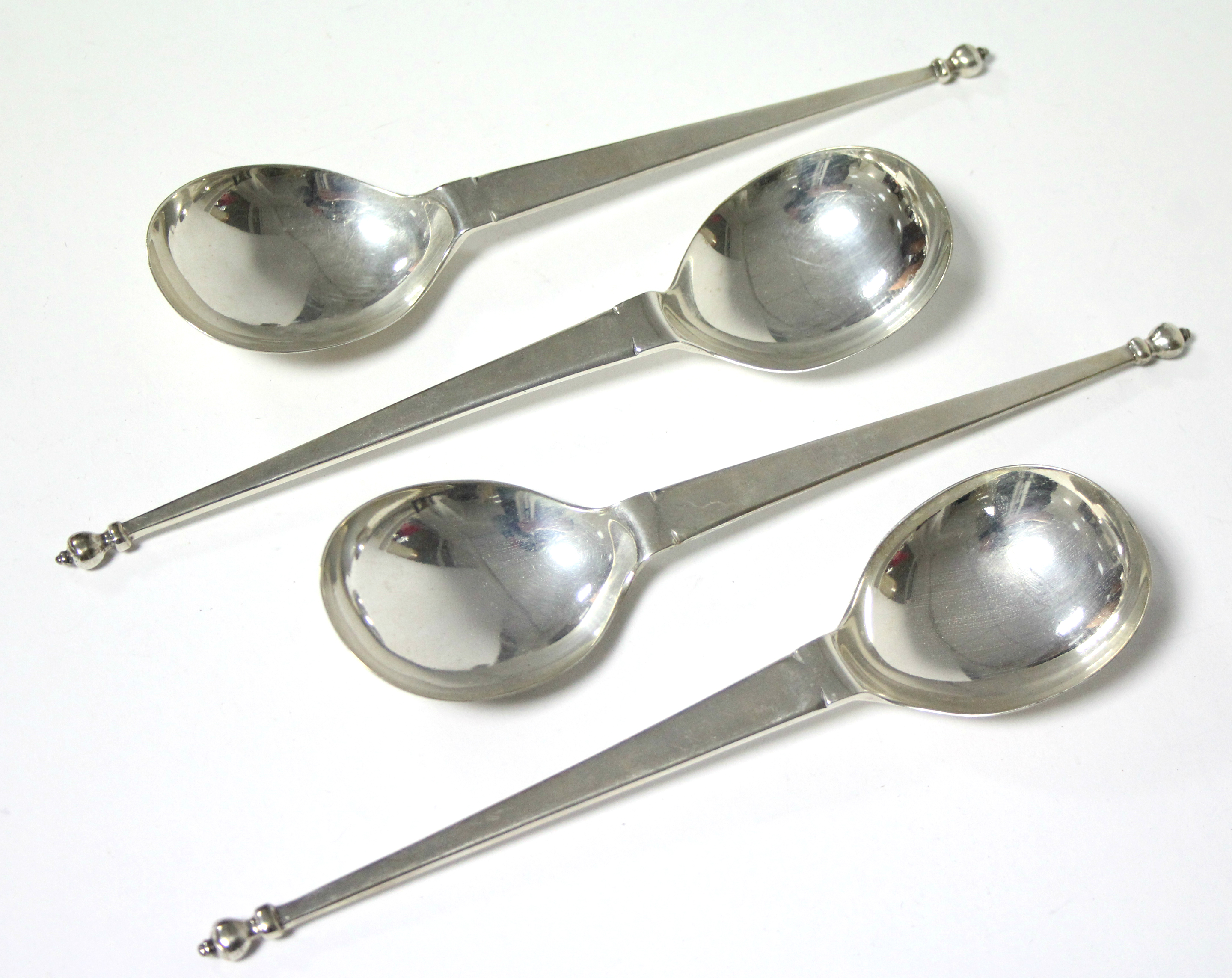 A set of four serving or soup spoons, each with baluster knop to the long flat tapered stem, &