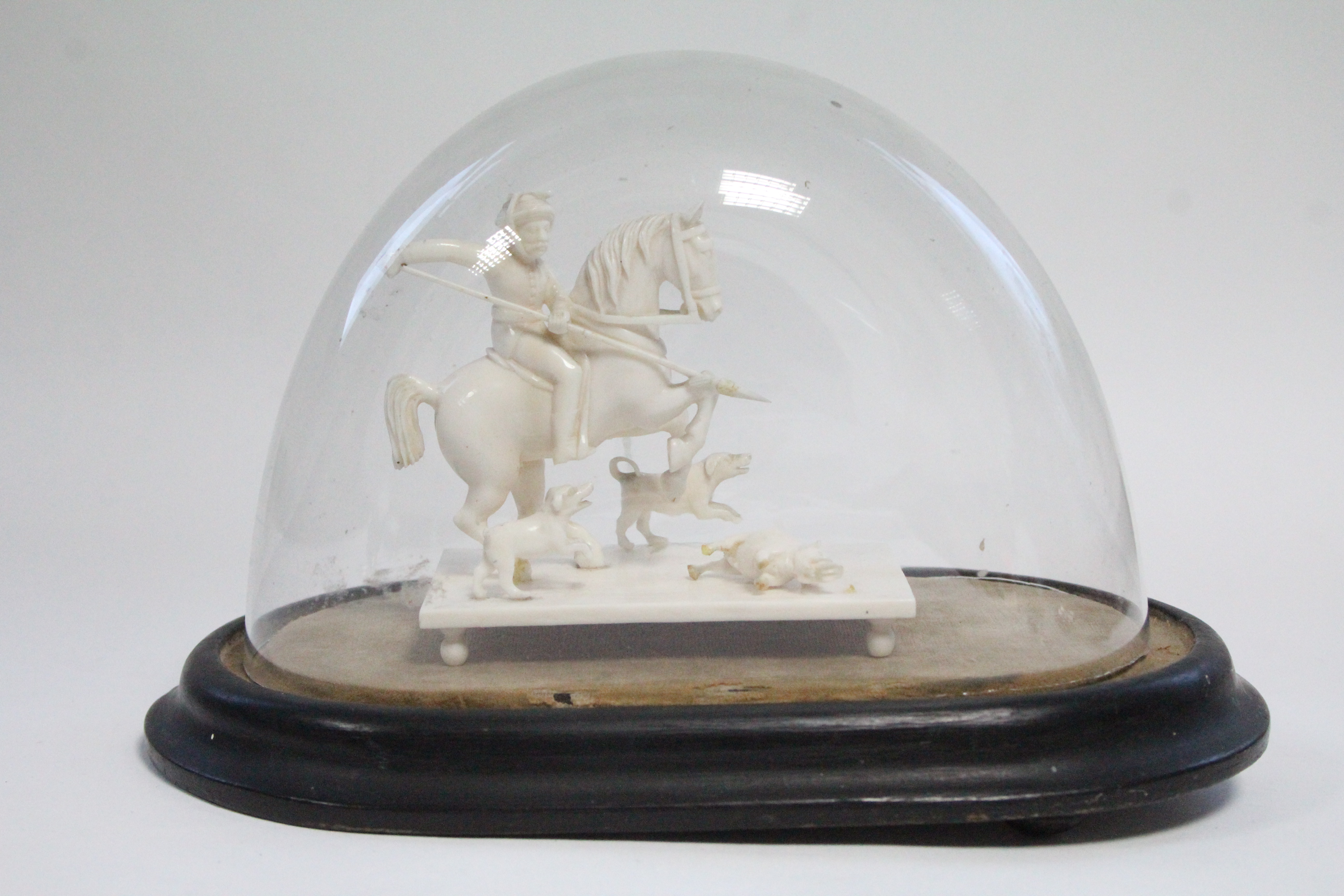 A 19th century Indian carved ivory equestrian group of a boar hunt, 3¼” high x 3½” wide; under glass