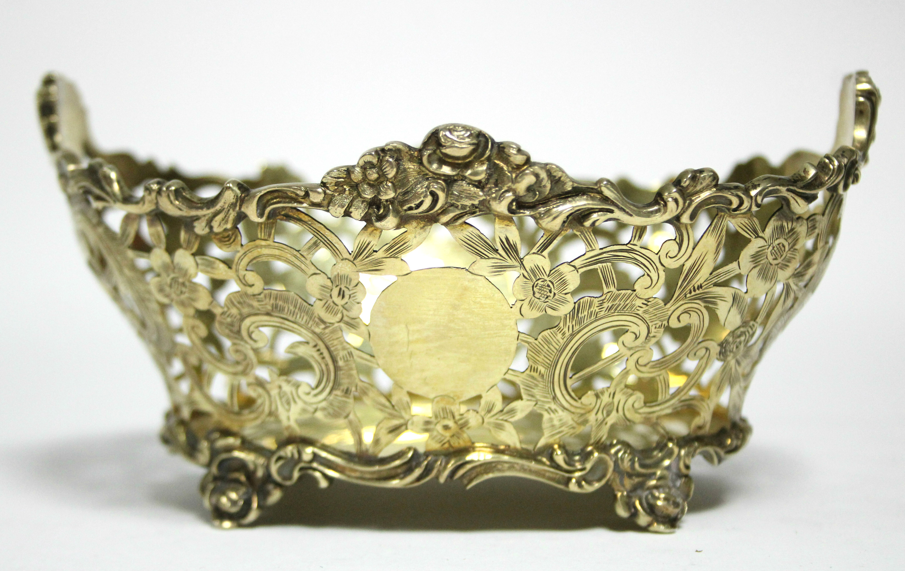 An Edwardian silver-gilt pierced oval dish with shaped cast scroll rim & feet, & engraved flower & - Image 3 of 3