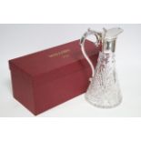 A modern cut glass claret jug of round tapered form, with silver neck-mount, hinged lid, & scroll