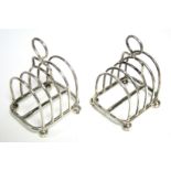 A matched pair of four-division toast racks, each with centre ring handle & on four ball feet, 4¼”
