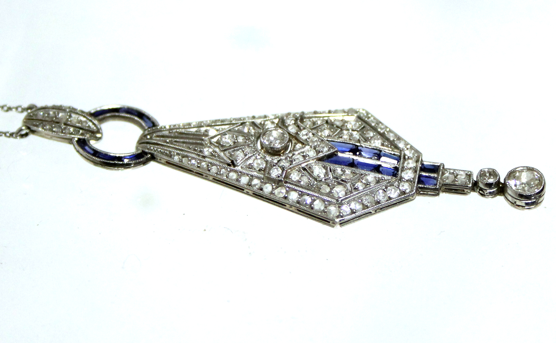 AN ART DECO DIAMOND & SAPPHIRE PENDANT of tapered angular form, set numerous graduated diamonds &