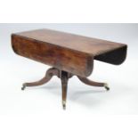 A regency mahogany drop-leaf dining table, the rounded rectangular top with rosewood crossbanding,