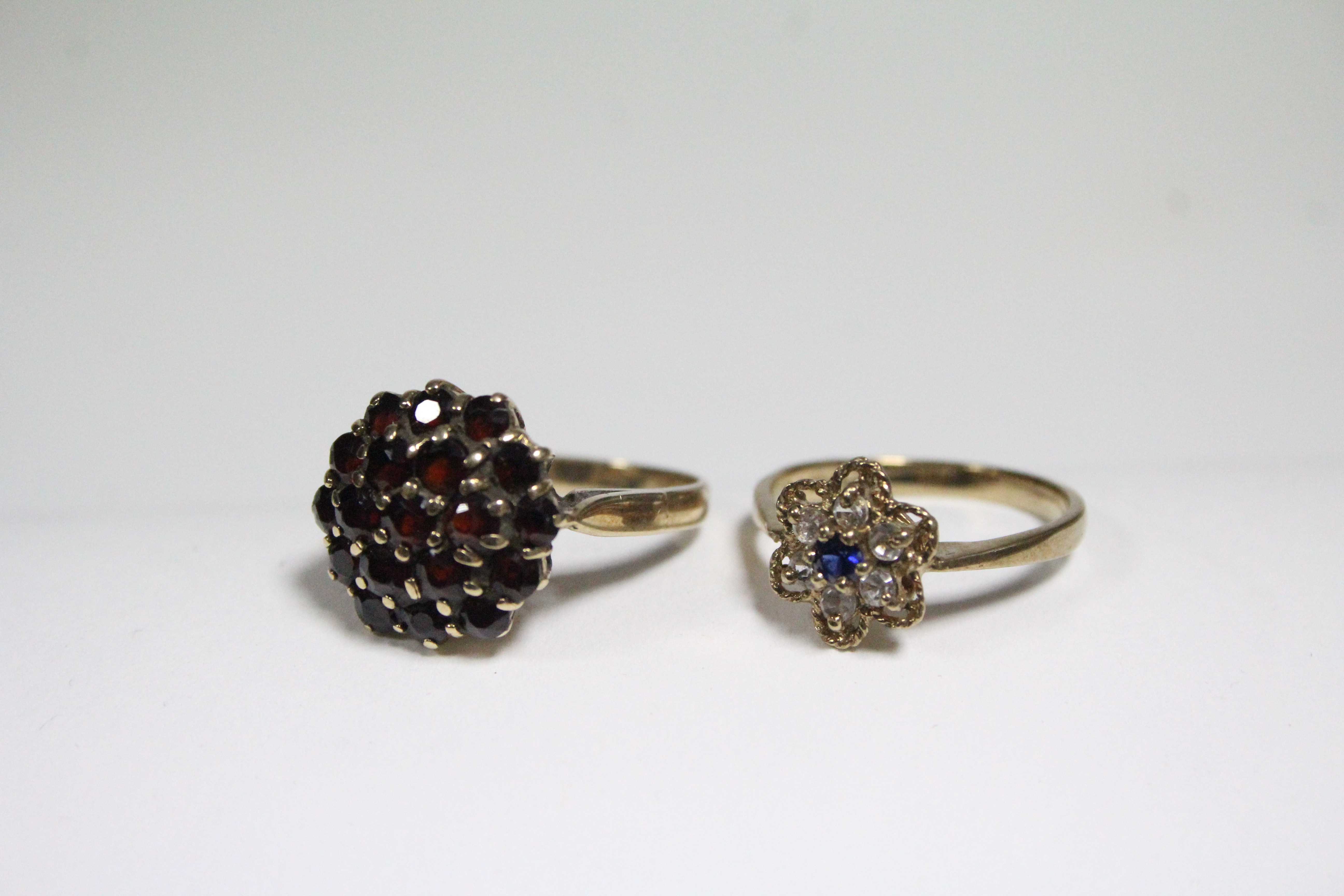 A 9ct. gold ring set cluster of blue & white sapphires; a gold ring set garnet cluster; & a pair - Image 2 of 4