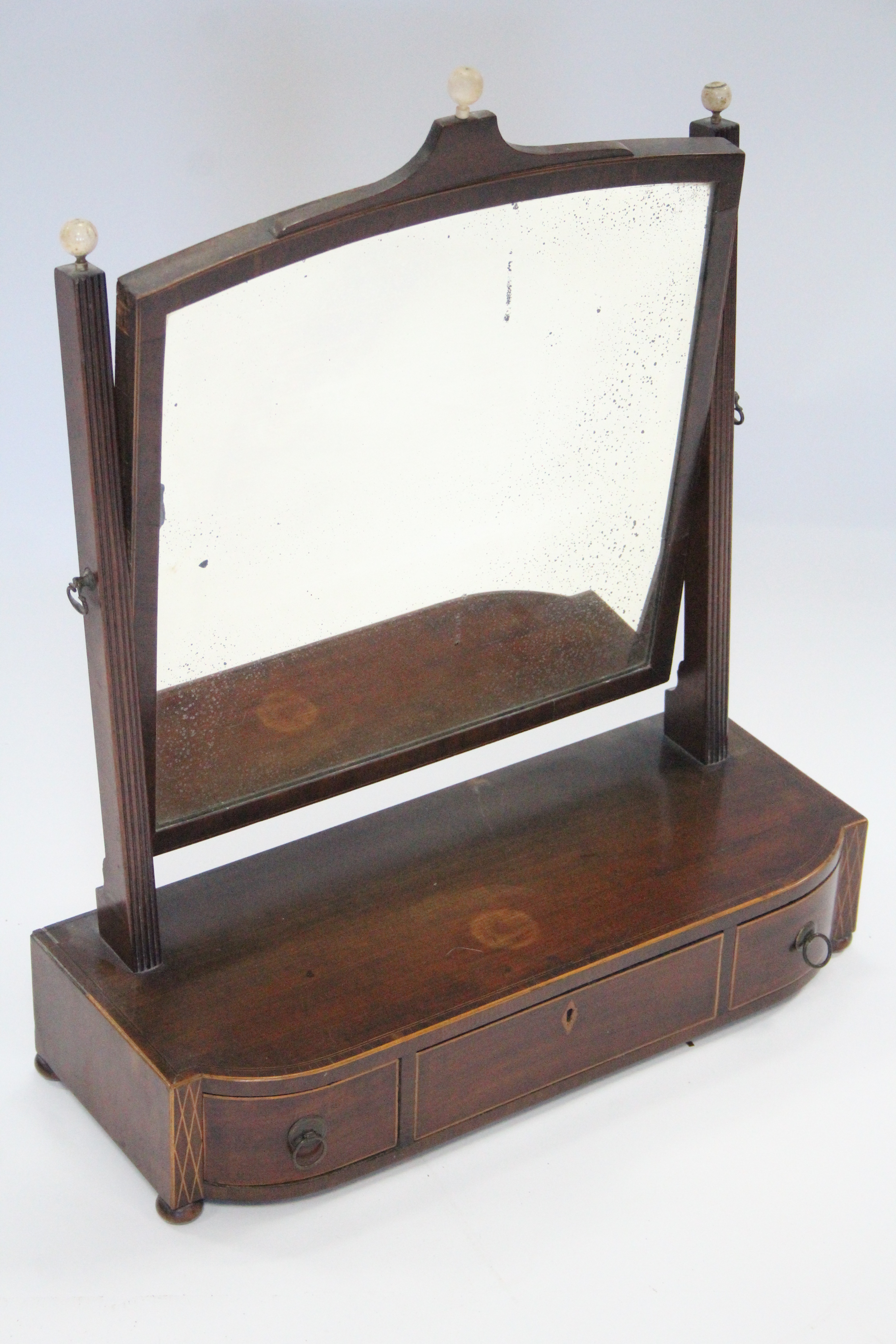 A regency inlaid mahogany rectangular swing toilet glass with turned ivory ball finials, the base