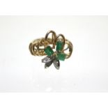 A 14ct. gold ring with looped panel set three emeralds & three small diamonds; London import marks