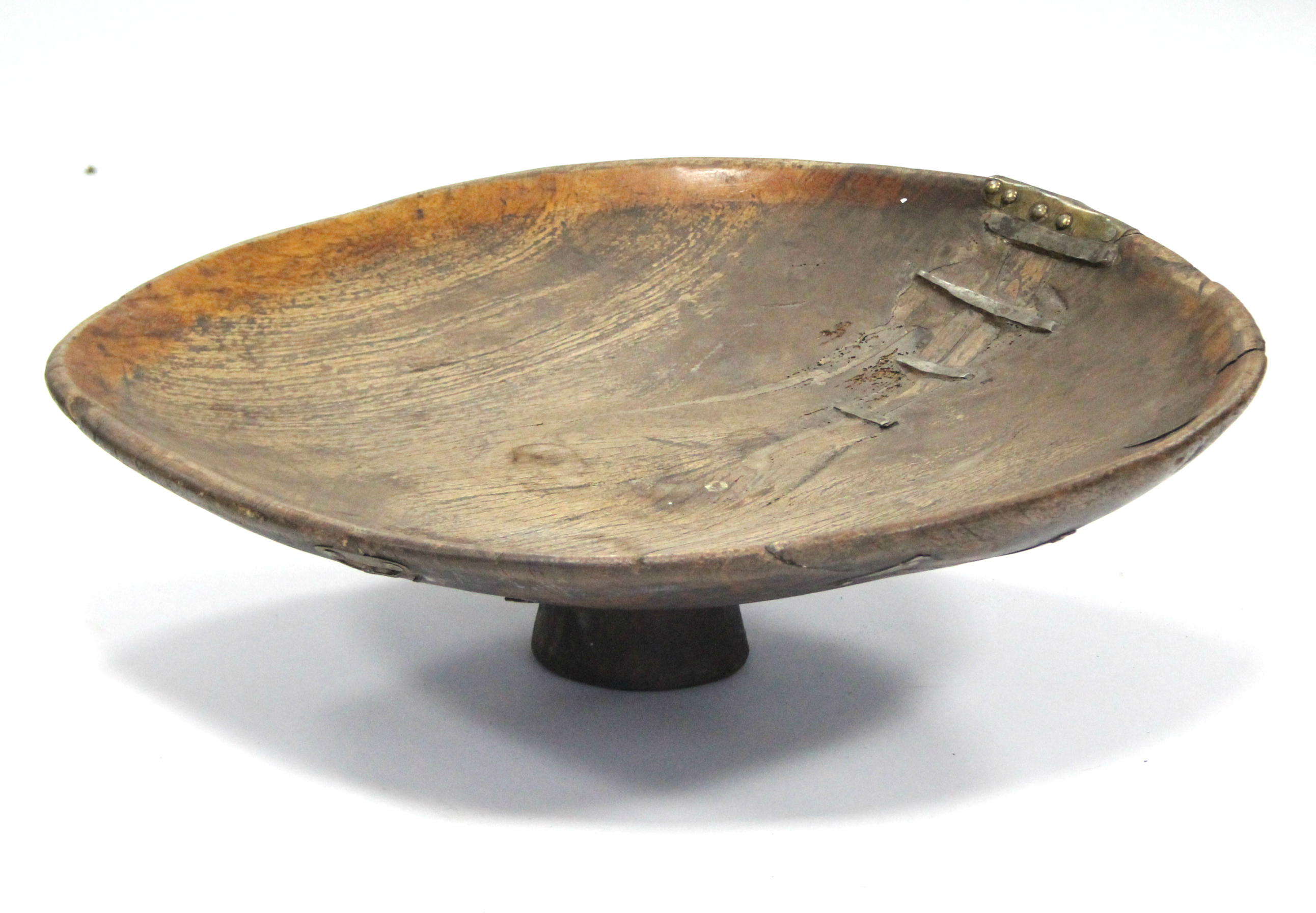 An antique Moroccan large wooden couscous bowl, on stem foot; 27” diam. (old rivet repairs).