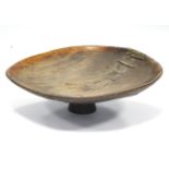 An antique Moroccan large wooden couscous bowl, on stem foot; 27” diam. (old rivet repairs).