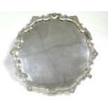A GEORGE V SALVER in the Paul de Lamerie style, with cast shell & rosette rim to the raised shaped