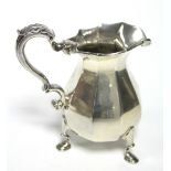 A Britannia standard cream jug in the early 18th century style, on nine-sided baluster shape, with