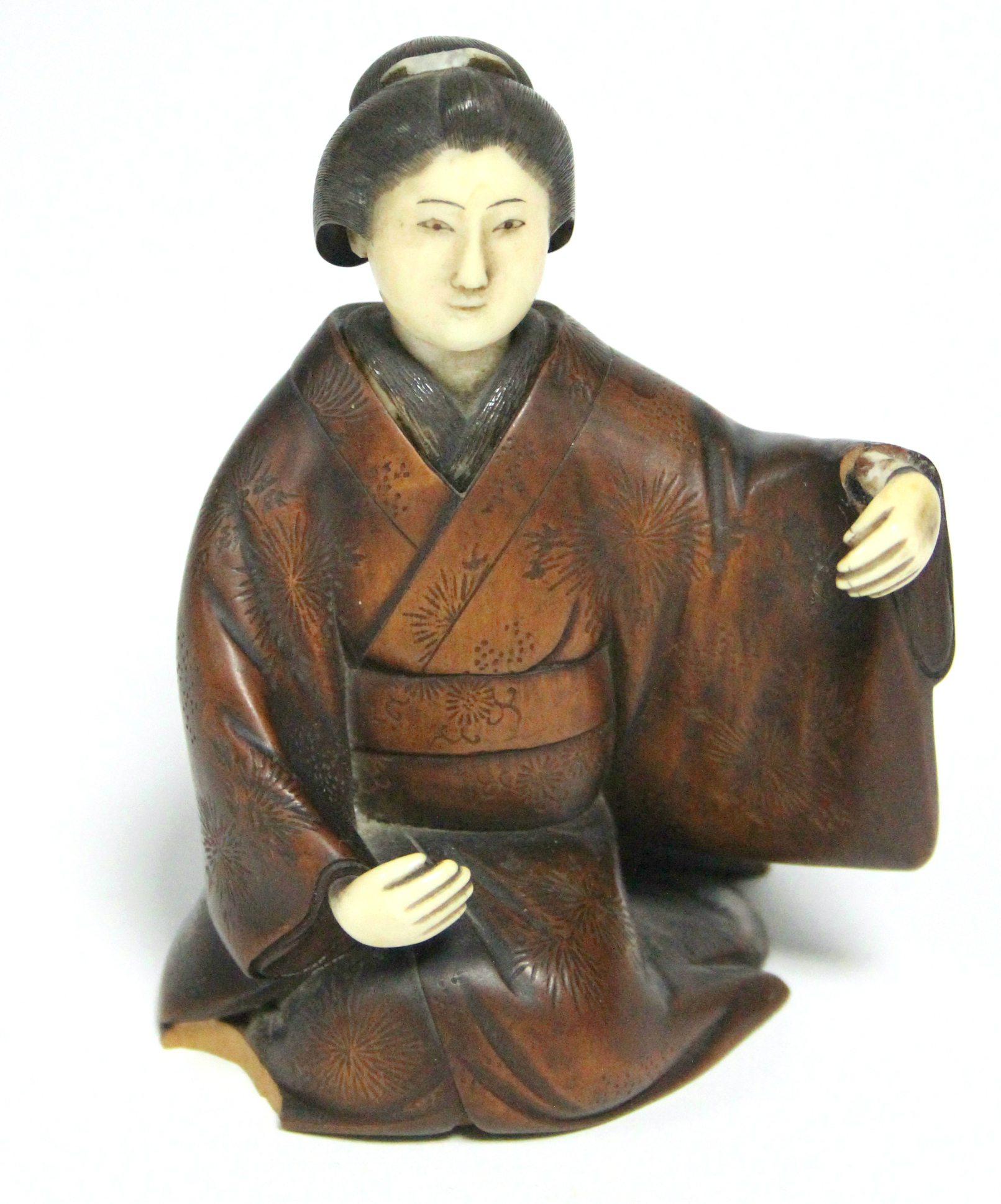 A late 19th century Japanese wood okimono of a kneeling Geisha, with ivory head & hands, signed on a