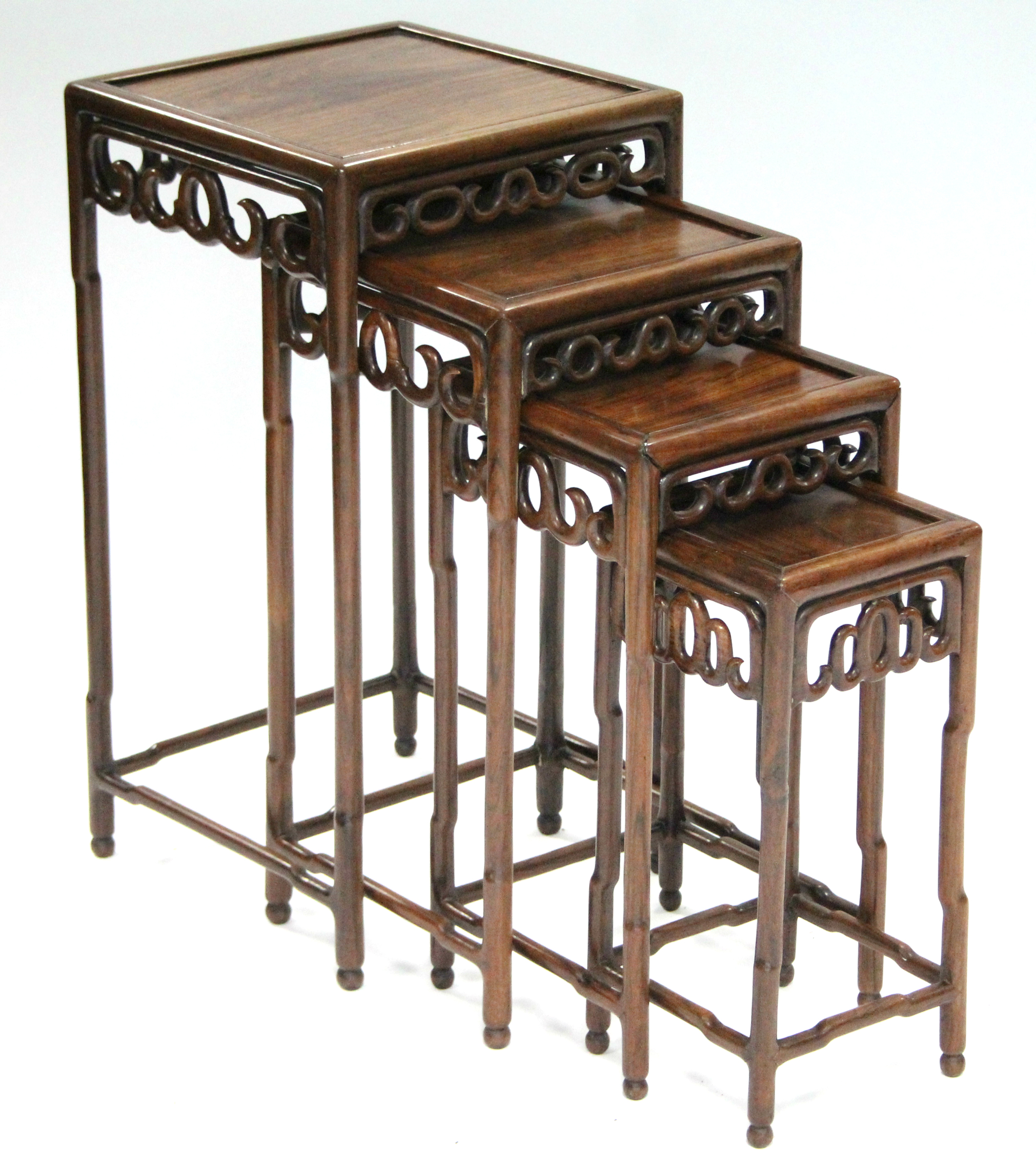 A nest of four Chinese hardwood occasional tables with pierced frieze, on faux-bamboo legs &