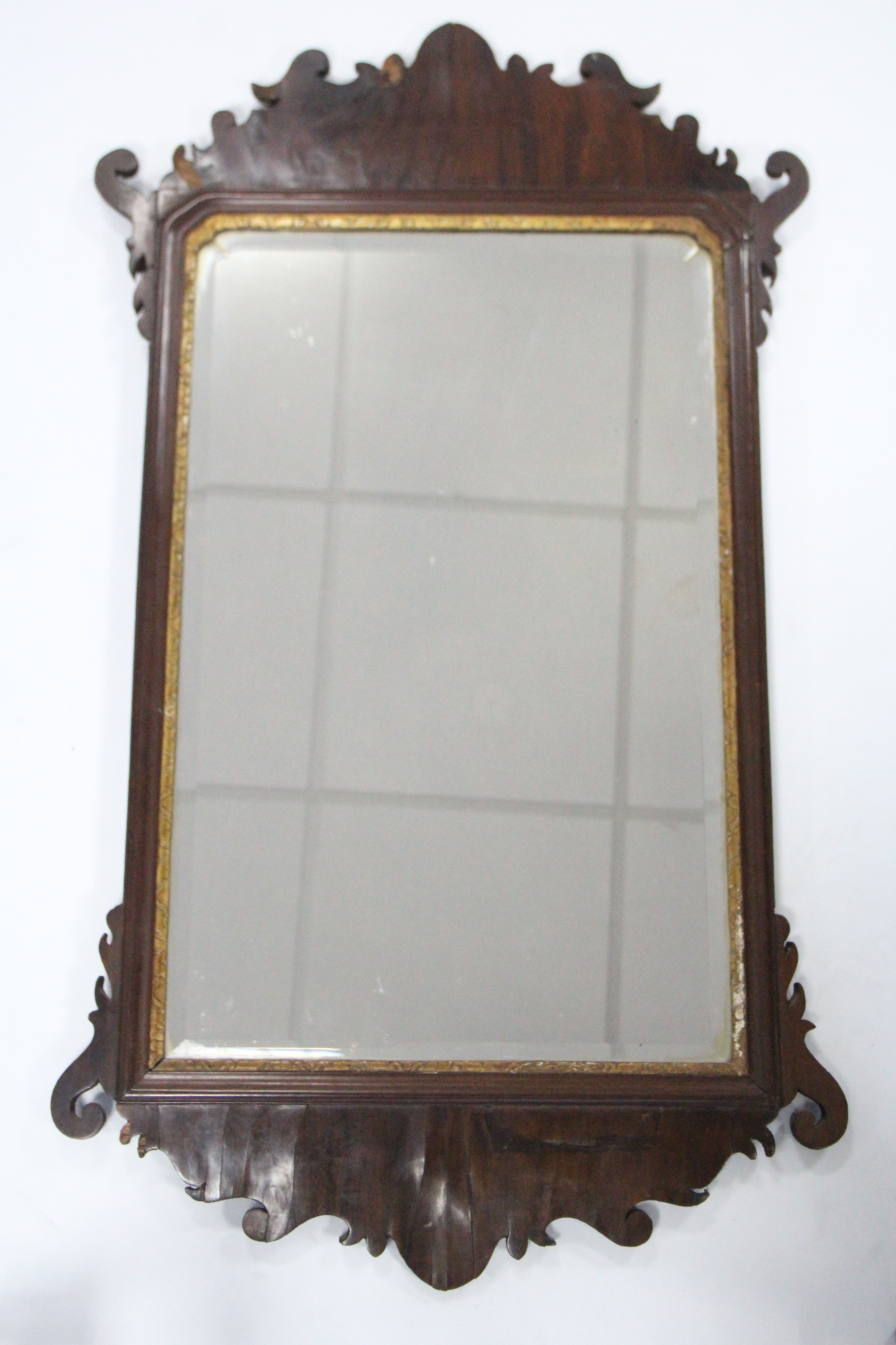 An 18th century rectangular wall mirror inset bevelled plate, in mahogany frame with fret-carved