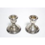 A pair of dwarf candlesticks on wide circular bases with beaded rims; 2½” high. Birmingham 1991,