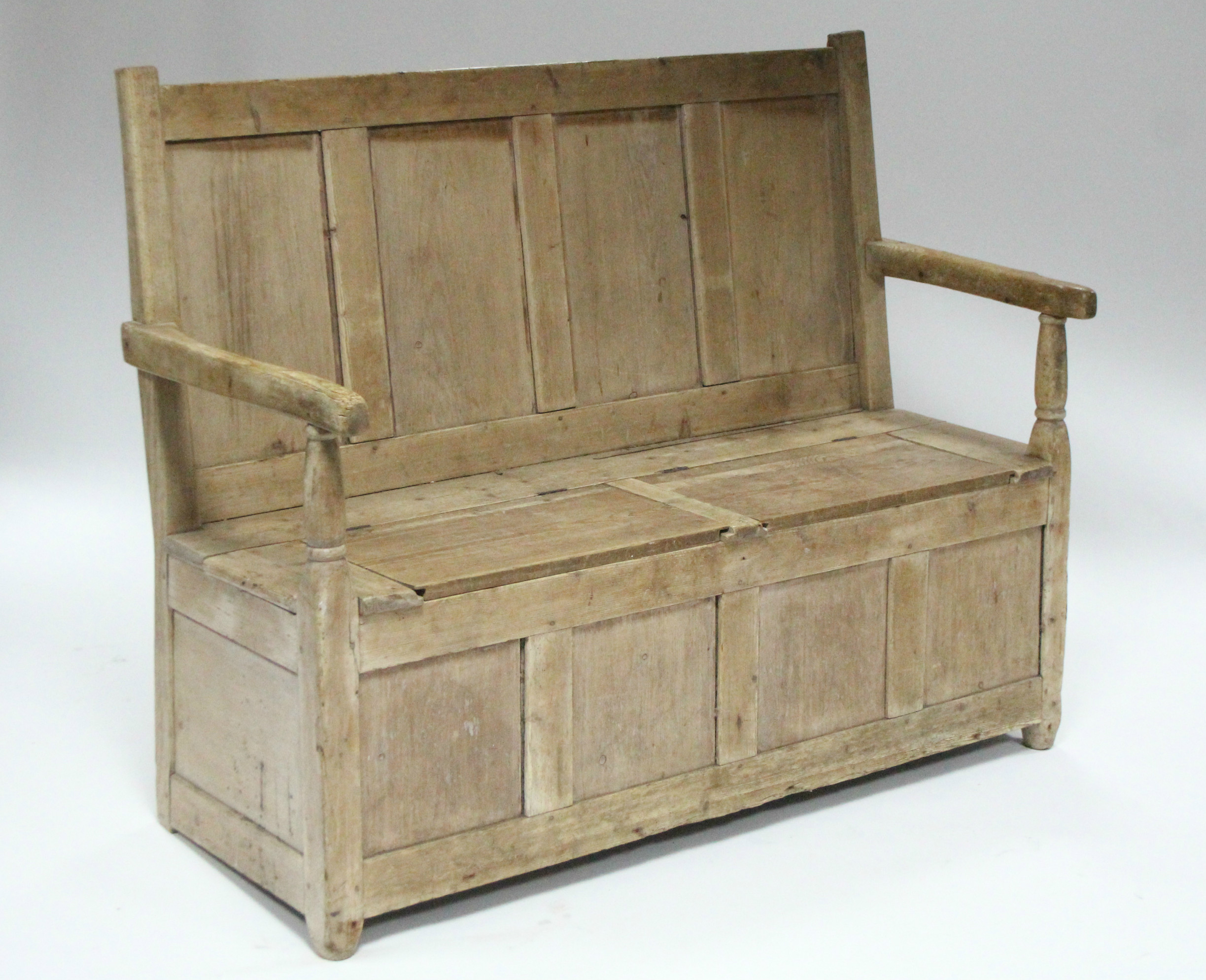 A 19th century pine box-seat settle with panelled back & open arms; 54” wide.