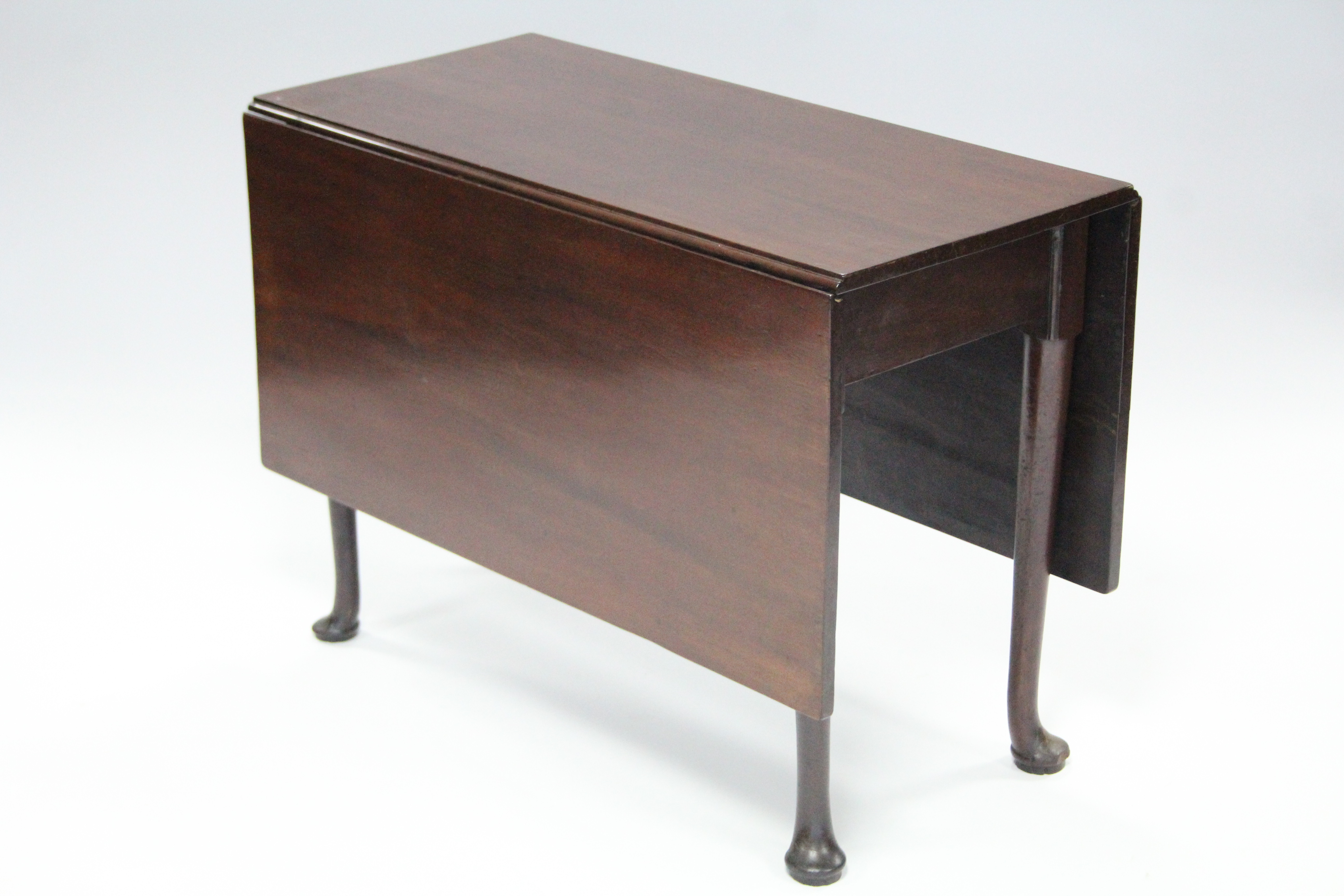 An early 19th century mahogany drop-leaf supper table, the rectangular top on four slender tapered