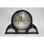 An Art Deco mantel clock with 5” diam. silvered dial, eight-day striking movement, in ebonised