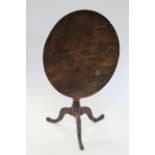 A late 18th century oak tripod table, the circular tilt top on turned column & three cabriole